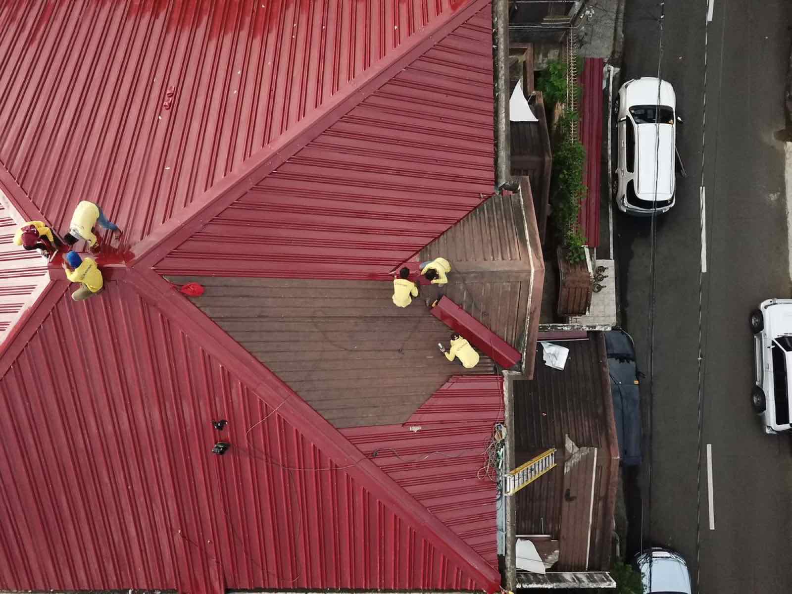 Crew applying a reflective roof coating on a residential roof