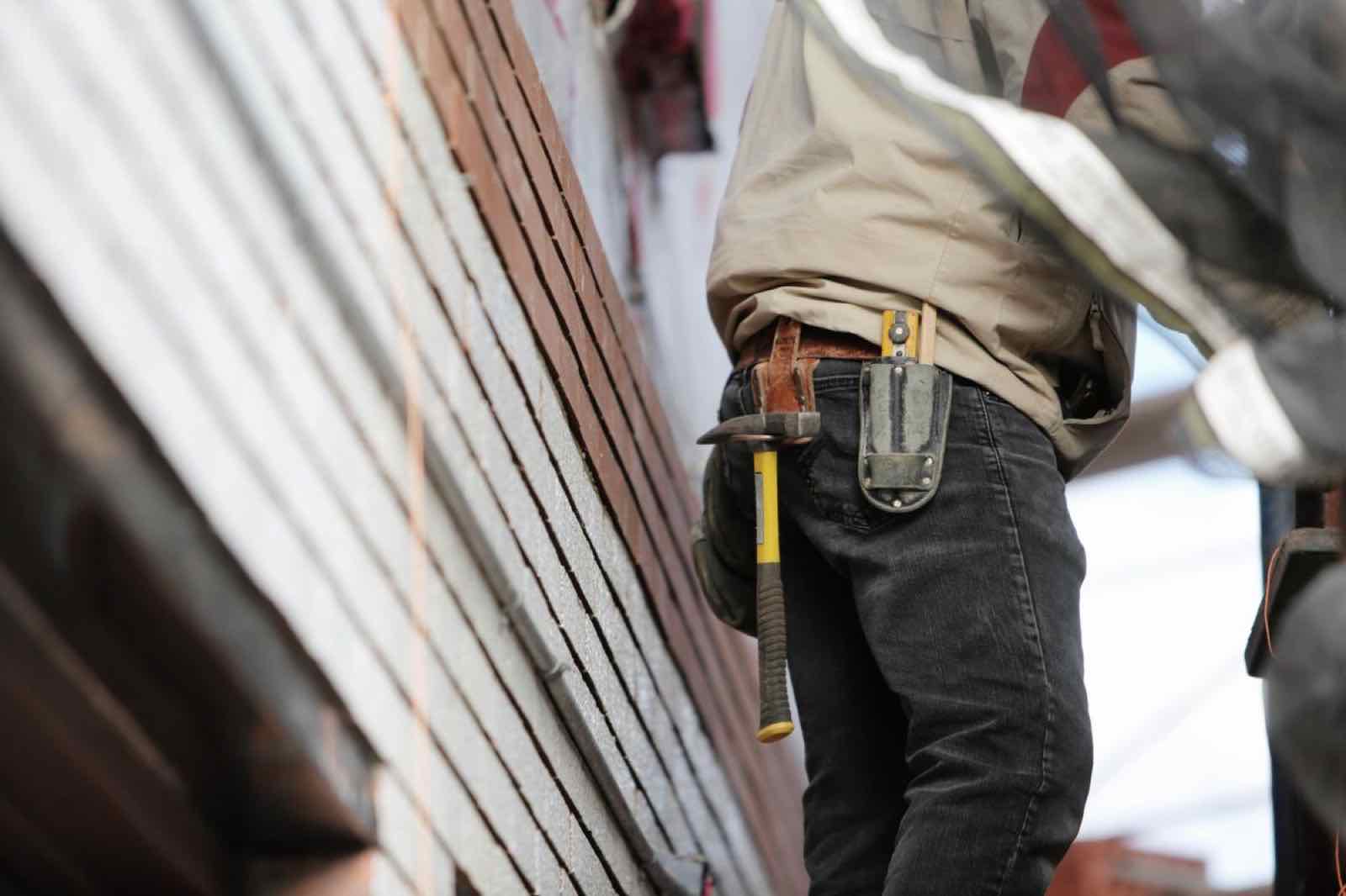 Close-up of a handyman's tool belt with a hammer and tape measure