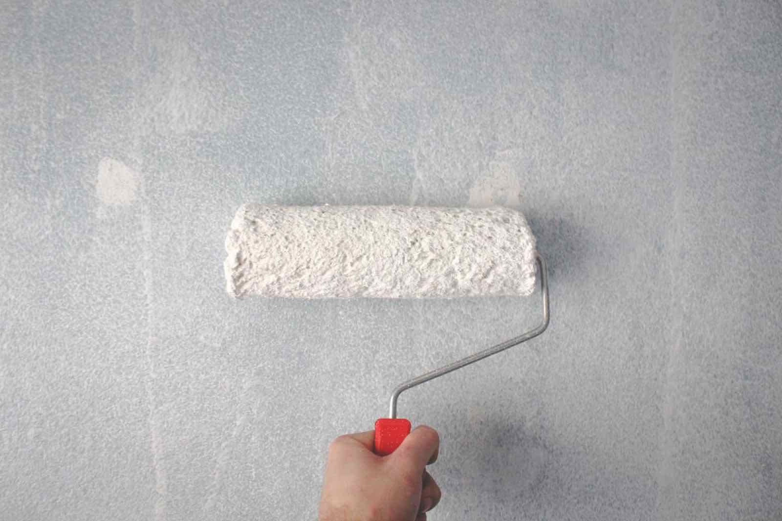 Paint roller applying fresh paint to an interior wall